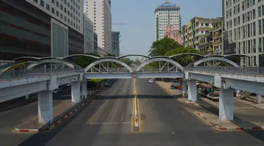 Sebuah mobil melintasi jalanan yang kosong di pusat Kota Yangon, Myanmar, Rabu (24/3/2021. Demonstran antikudeta mencoba taktik baru yang mereka sebut pemogokan 'diam', menyerukan orang-orang untuk tinggal di rumah dan menutup bisnis. (AP Photo)