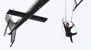 Akrobatis udara, Erendira Wallenda melambaikan tangan saat melakukan serangkaian aksi akrobatik di atas air terjun Niagara, New York, Kamis (15/6). Erendira bergelayutan di lingkaran besi yang dikaitkan pada sebuah helikopter. (AP Photo/Bill Wippert)