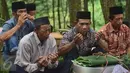 Sejumlah warga berdoa sebelum makan saat prosesi Sadranan Asyura di makam kiai kramat di bukit Tlogo Pucang, Kandangan, Temanggung, Rabu  (12/10).  (Liputan6.com/Gholib)