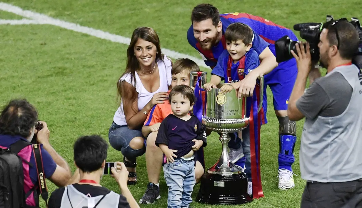 Bintang Barcelona, Lionel Messi bersama Antonella Roccuzzo dan anak-anaknya berpose saat merayakan gelar juara Copa Del Rey di Stadion Vicente Calderon, (27/5/2017). (AFP/Javier Soriano)