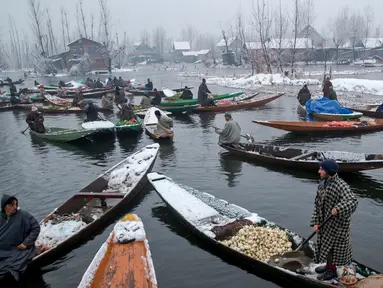 Sejumlah pedagang berada di perahu menjual sayur dan buah-buahan di pasar terapung di danau Dal, Srinagar, Kashmir India, (25/1). Pasar ini menjual sayuran yang dipetik langsung dari sebuah perkebunan yang juga ada di danau tersebut. (AP Photo/Dar Yasin)