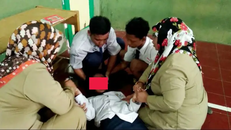 Guru dan siswa berusaha menenangkan siswi yang kesurupan. (Foto: Liputan6.com/Muhamad Ridlo)