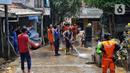 Personel dari Dinas Penanggulangan Kebakaran dan Penyelamatan (Gulkarmat) Provinsi DK Jakarta menyemprotkan air untuk membersihkan endapan sisa lumpur di permukiman warga di kawasan Rawajati, Kalibata, Jakarta Selatan, Jakarta, Rabu (5/3/2025). (Liputan6.com/Angga Yuniar)
