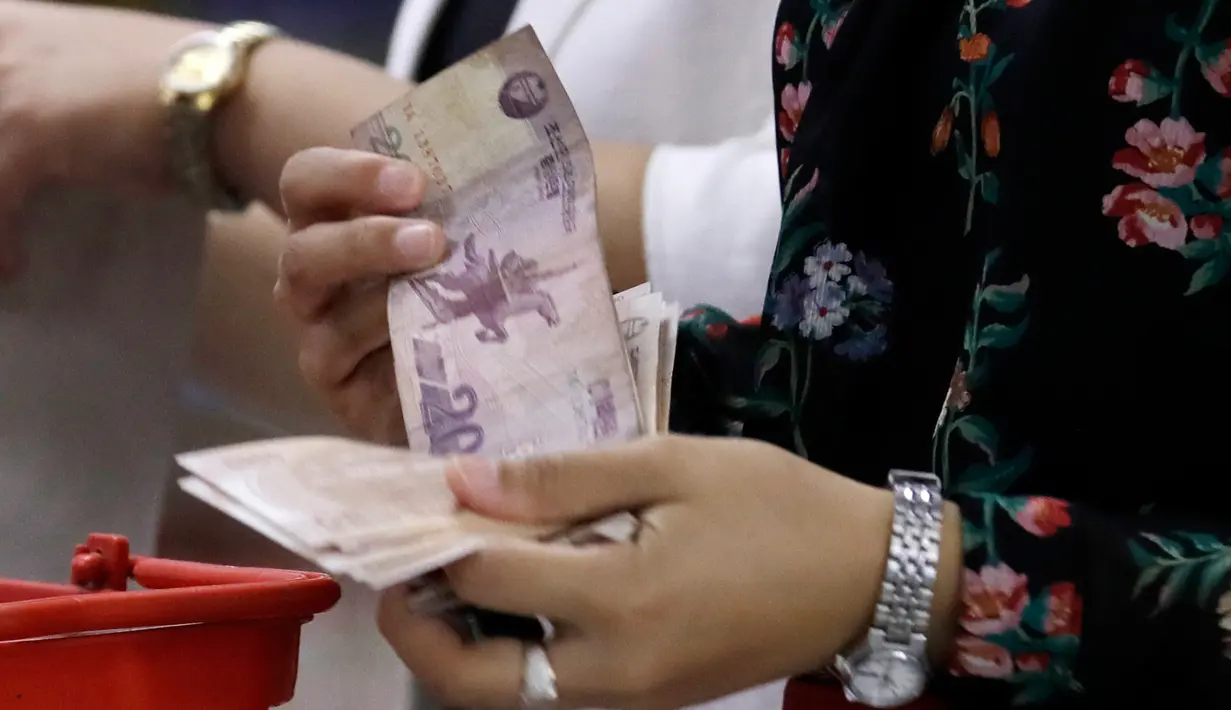 Seorang wanita membayar di kasir di supermarket di Pyongyang, Korut (12/9). Banyak produk dalam negeri terlihat di rak-rak supermarket tersebut sebagai bagian dari upaya membangun ekonominya dan meningkatkan standar hidup nasional. (AP Photo/Kin Cheung)