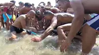 Beberapa orang yang sedang berlibur ke suatu pantai di Italia menolong melepaskan mata pancing dari mulut seekor hiu.