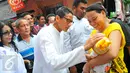Cawagub DKI Jakarta, Sandiaga Uno menyapa seorang bayi yang digendong ibunya saat mengunjungi kawasan Tendean, Jakarta, Sabtu (5/11). Di kawasan itu, Sandiaga berjanji akan memberdayakan ibu-ibu melalui pembukaan lapangan kerja (Liputan6.com/Angga Yuniar)