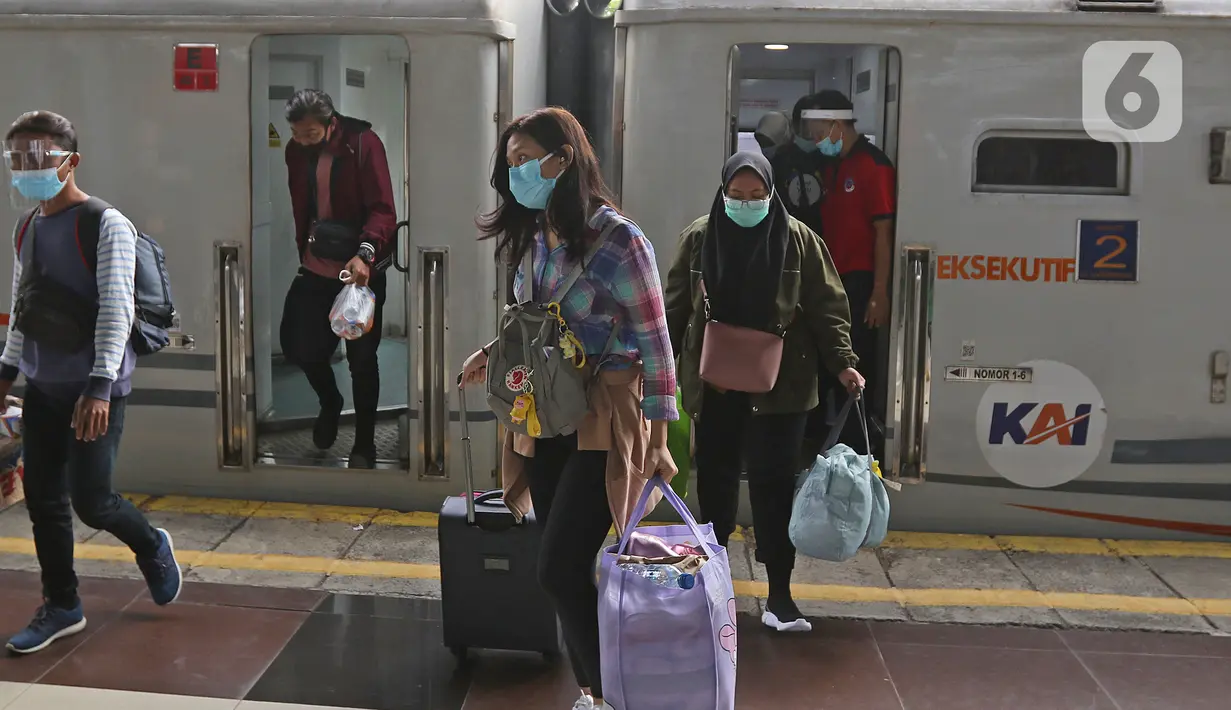 Penumpang kereta api Dharmawangsa Surabaya Pasarturi–Pasar Senen tiba di stasiun Senen, Jakarta, Minggu (3/01/2021). PT KAI Daop 1 memperkirakan sekitar 15.000 - 16.000 lebih penumpang KA Jarak Jauh turun di area Daop 1 Jakarta dari wilayah Jabar, Jateng dan Jatim. (Liputan6.com/Herman Zakharia)