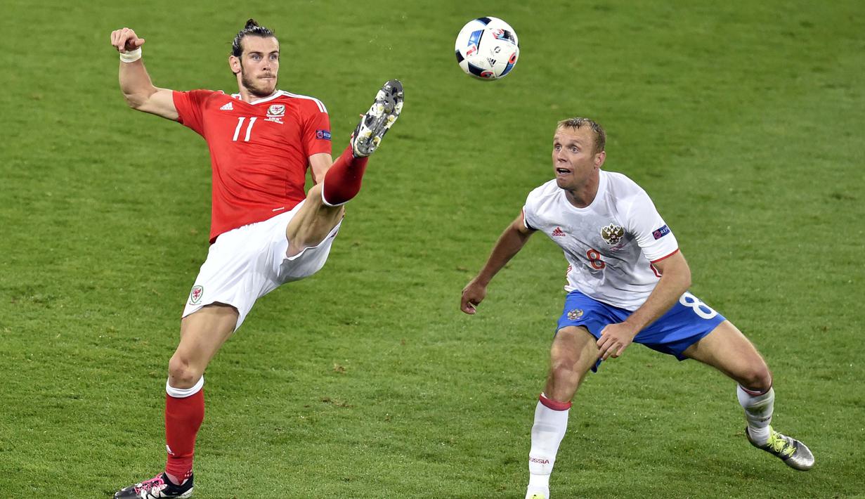 Aksi Gareth Bale (kiri) saat melewati hadangan pemain Rusia, Denis Glushakov pada laga grup B Euro cup 2016 di Stadion Municipal, Toulouse, Selasa (21/6/2016) dini hari WIB. Wales menang 3-0. (AFP/Pascal Pavani)