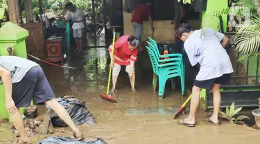 Warga membersihkan lumpur sisa banjir di halaman rumahnya di perumahan Ciledug Indah, Tangerang Senin (21/2/2021). Banjir yang menggenangi perumahan tersebut membuat warga mengalami kerugian cukup besar karena barang-barang berharga mereka rusak parah. (Liputan6.com/Angga Yuniar)