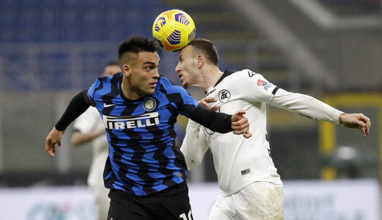 Striker Inter Milan, Lautaro Martinez, duel udara dengan pemain Spezia, Ardian Ismajli, pada laga Liga Italia di Stadion Giuseppe Meazza, Minggu (20/12/2020). Inter Milan menang dengan skor 2-1. (AP/Luca Bruno)