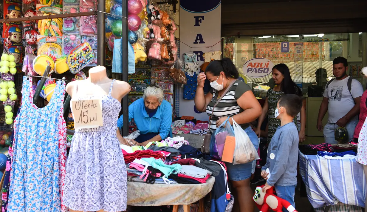 Pedagang kaki lima dan pembeli terlihat di jalan di Asuncion (22/2/2022). Pemerintah Paraguay mengumumkan pada Selasa (22/2) bahwa mereka mencabut semua pembatasan sanitasi terkait pandemi COVID-19, kecuali untuk penggunaan masker di dalam ruangan dan di tempat ramai. (AFP/Norberto Duarte)