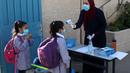Seorang pelajar menjalani pemeriksaan suhu tubuh di sekolah pada hari pertama tahun ajaran baru di kamp pengungsi Al-Amari di Kota Ramallah, Tepi Barat (6/9/2020). Pelajar Palestina memulai tahun ajaran baru setelah belajar di rumah selama enam bulan akibat Covid-19. (Xinhua/Nidal Eshtayeh)