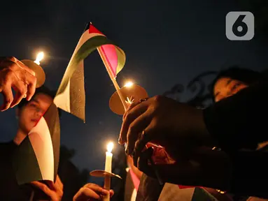 Sejumlah elemen masyarakat menyalakan lilin saat mengikuti Aksi Damai Bela Palestina di Kedutaan Besar Palestina, Jakarta, Kamis (2/11/2023). (Liputan6.com/Faizal Fanani)