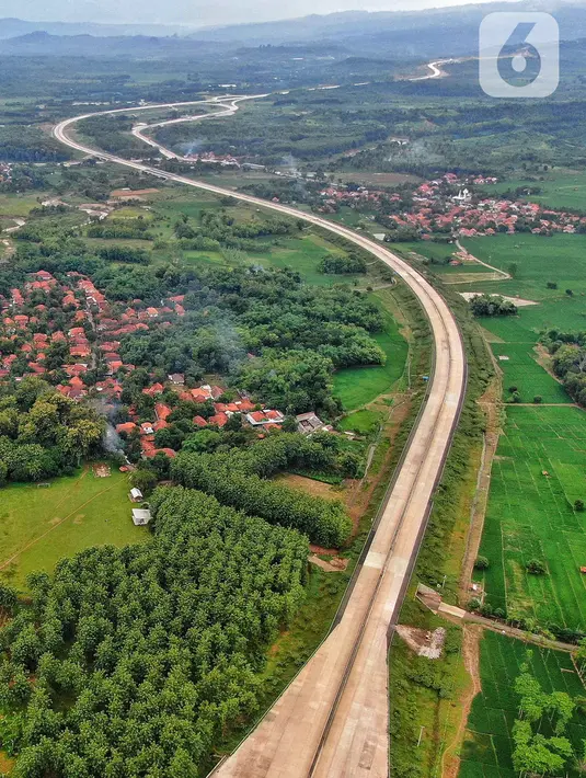 Foto udara pembangunan Gerbang Tol Ujung Jaya Utama bagian dari Tol Cileunyi-Sumedang-Dawuan (Cisumdawu) seksi enam di Kabupaten Majalengka, Jawa Barat, Rabu (28/12/2022). Kementerian Koordinator Bidang Perekonomian melalui KPPIP meninjau progress dan optimalisasi untuk akses jalan tol menuju Bandara Kertajati dan solusi antisipasi kemacetan jalan nasional Bandung ke Majalengka serta target fungsional secara keseluruhan di kwartal satu 2023 dalam mendukung arus mudik lebaran. (Liputan6.com/Angga Yuniar)