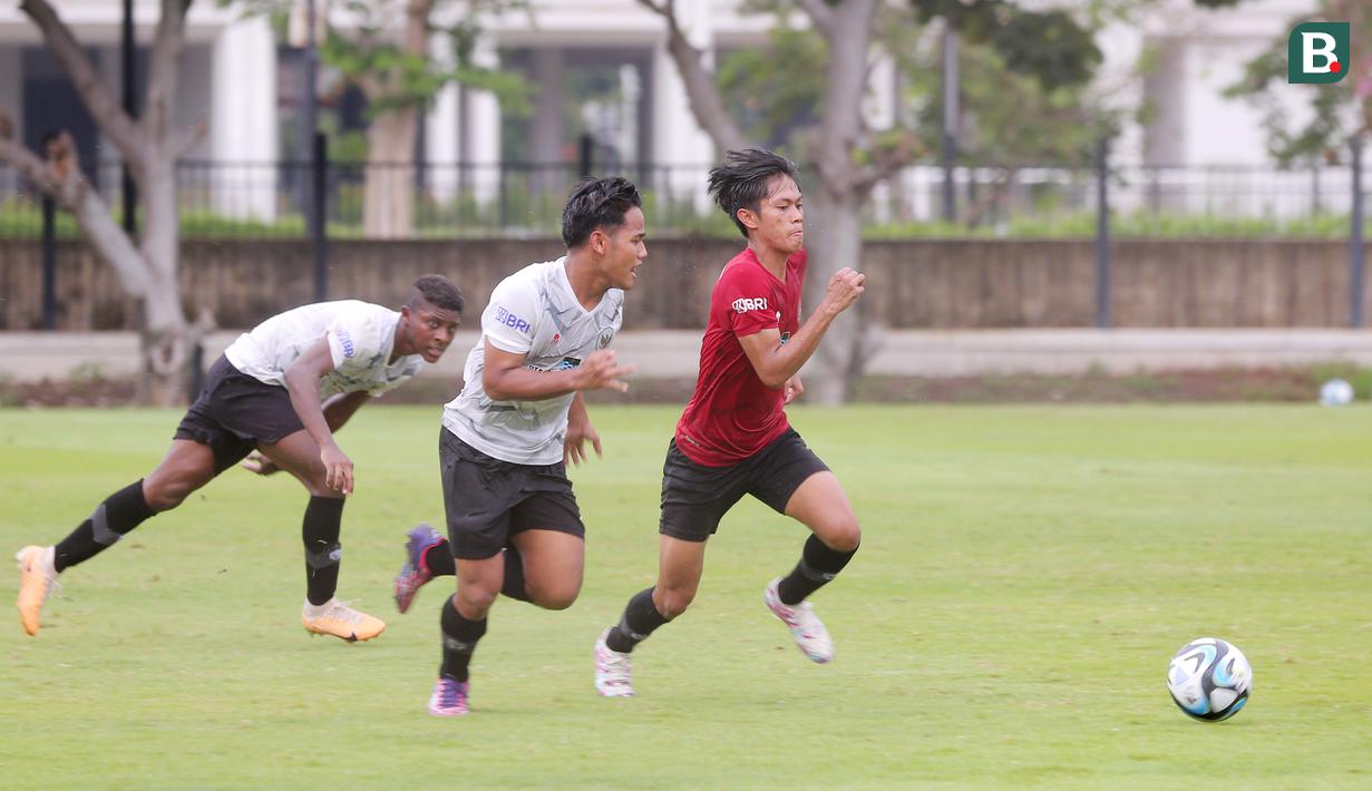 Pemain Timnas Indonesia U-20, Muhammad Kafiatur (kanan) berebut bola dengan Tony Firmansyah (tengah) saat sesi latihan di Lapangan A Senayan, Jakarta, Kamis (4/1/2023). (Bola.com/M Iqbal Ichsan)