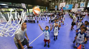 Anak-anak memasukan bola basket ke dalam keranjang pada program Junior NBA Indonesia di Cilandak, Jakarta, Sabtu (24/3). Peserta diberikan pelatihan tentang dasar-dasar olahraga basket. (Liputan6.com/Fery Pradolo)