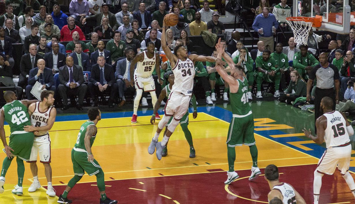 Aksi pemain Milwaukee Bucks, Giannis Antetokounmpo mencoba melakukan dunk saat diadang pemain Boston Celtics, Aron Baynes pada laga NBA di basketball game di Milwaukee, (26/10/2017). Boston menang 96-89. (AP/Tom Lynn)