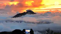 Pengunjung mengambil gambar Gunung Merapi dari atas Gunung Merbabu di Selo, Boyolali, Jawa Tengah, Sabtu (2/2/2019). Aktivitas Gunung Merapi dalam beberapa hari terakhir masih tinggi dan masih berada di level 2 atau waspada. (Merdeka/Arie Basuki)