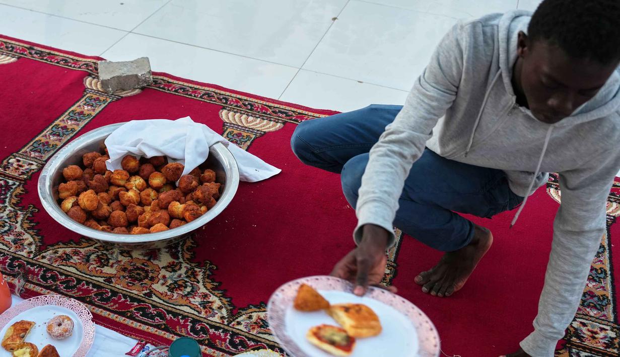 Teranga diwujudkan melalui berbagi makanan, seringkali makan dari satu piring besar bersama-sama (seperti hidangan nasional Thieboudienne), yang mengajarkan persatuan dan kesabaran. Tampak dalam foto, umat Muslim bersiap untuk iftar, yaitu berbuka puasa selama bulan suci Ramadan di Dakar, Senegal, Kamis, 5 Maret 2026. (AP Photo/Misper Apawu)