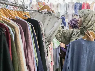 Warga memilih pakaian yang dijual di Pasar Tanah Abang, Jakarta, Minggu (1/12/2024). (Liputan6.com/Herman Zakharia)