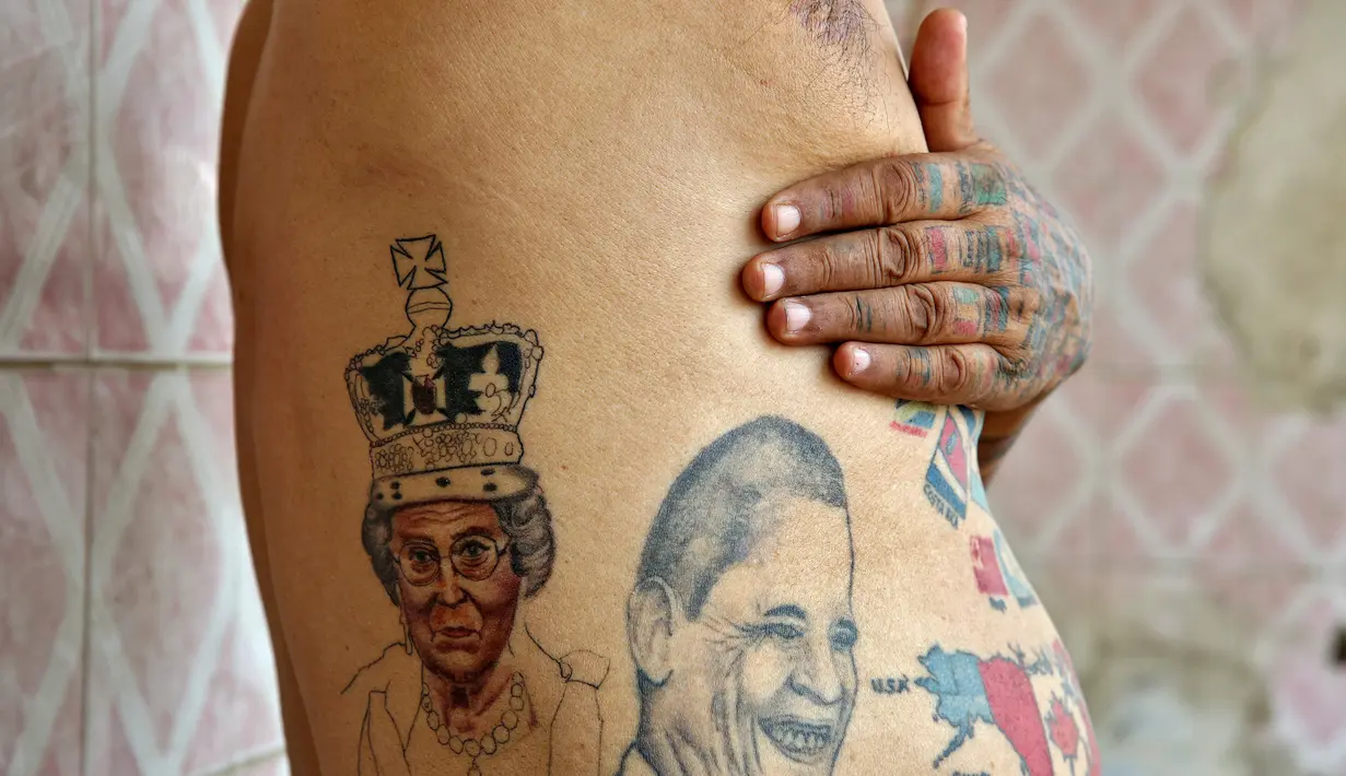 Guinness Rishi menunjukan tato bergambar seorang ratu di tubuhnya di New Delhi, India (20/5). Guinness Rishi merupakan pemegang rekor dunia yang paling banyak menato bendera negara dari seluruh dunia. (REUTERS/Cathal McNaughton)