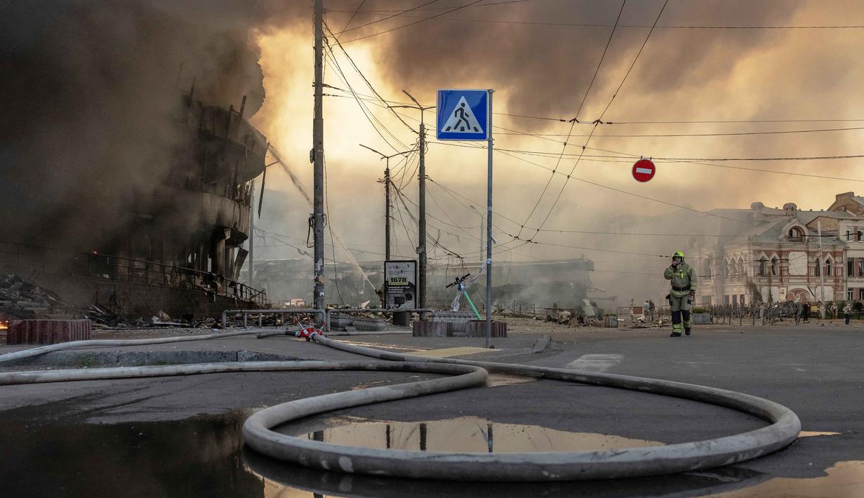 Petugas pemadam kebakaran Ukraina bekerja di lokasi di samping bangunan yang rusak parah setelah serangan Rusia di Minggu 24 Mei 2026, di tengah invasi Rusia ke Ukraina. (Roman PILIPEY/AFP)