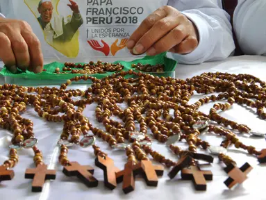 Seorang narapidana di penjara Wanita Virgen de Fatima membuat rosario kayu buatan tangan di Lima, Peru (12/1). Penjara tersebut menghasilkan 33.000 rosario untuk dijual di toko-toko ibukota Peru, Lima. (AFP Photo/Cris Bouroncle)