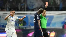 Pemain Paris Saint-Germain, Lucas Beraldo, mendpat kartu merah dari wasit saat melawan Marseille dalam duel pekan ke-27 Ligue 1 2023/2024 di Stade Velodrome, Senin (1/4/2024). (AFP/Christophe Simon)