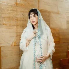 Busana transparan berlapis itu terlihat memberi kesan feminin sekaligus elegan, apalagi dipadukan dengan aksen bordir floral di sepanjang tepian veil dan area dress. [@adindathomas].