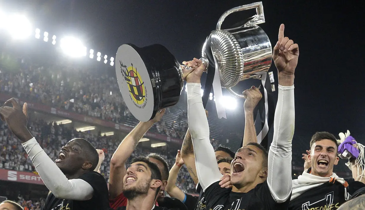 Para pemain Valencia merayakan gelar juara Copa del Rey usai mengalahkan Barcelona di Stadion Benito Villamarin, Sevilla, Sabtu (25/5). Barcelona kalah 1-2 dari Valencia. (AFP/Jose Jordan)