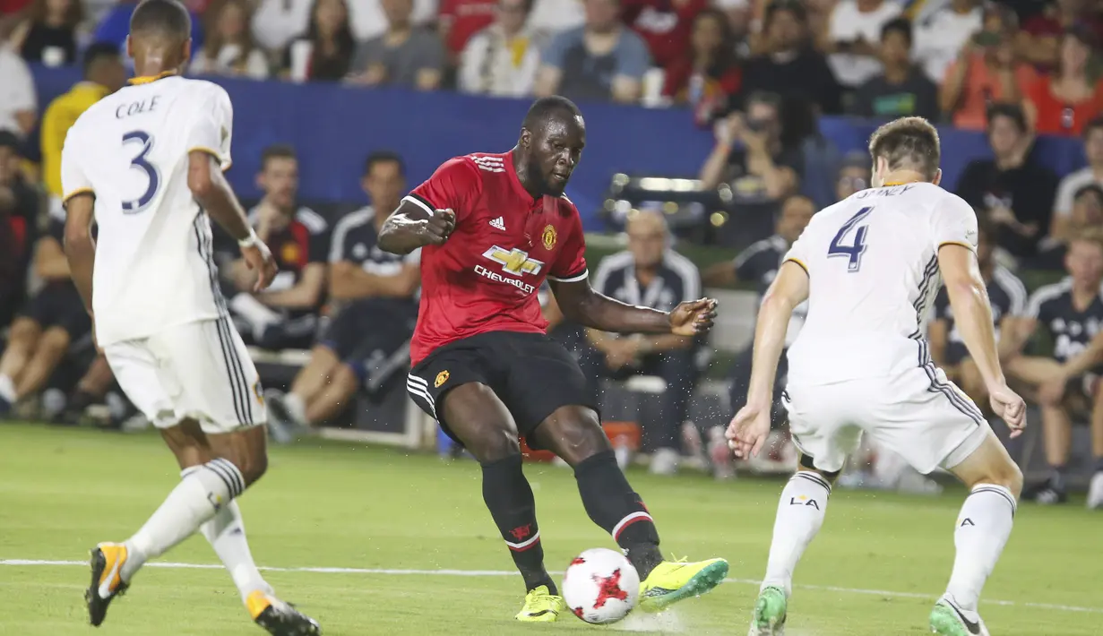 Aksi pemain Manchester United, Romelu Lukaku (tengah) melepaskan tembakan saat diadang dua pemain LA Galaxy pada laga persahabatan di California, Sabtu (15/7/2017).  (AFP/Ringo Chiu)
