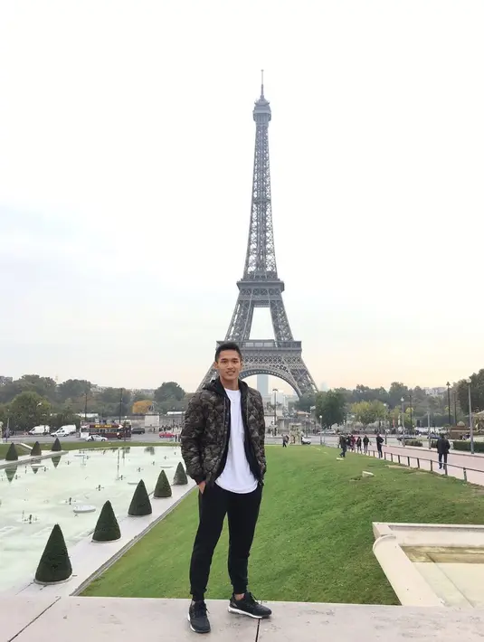 <p>Tampak berpose dengan latar Menara Eiffel, Jonatan Christie mengenakan t-shirt putih, yang ditumpuknya dengan puffer hoodie jacket bermotif army, jogger pants hitam, dan sneakers hitam. Foto: Instagram.</p>