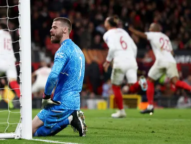 Kiper Manchester United, David de Gea, tampak kecewa setelah gawangnya dibobol pemain Sevilla pada leg kedua perempat final di Ramon Sanchez Pizjuan, Jumat (21/4/2023). Kiper MU ini menjadi biang kerok yang membuat Setan Merah tersingkir dari Liga Europa. Tiga gol Sevilla lahir dari semua kesalahannya. (AFP/Darren Staples)