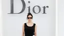 Rosalia tampil elegant effortless dengan sleeveless dress hitam beraksen bunga putih di pinggang [dok. Dior]