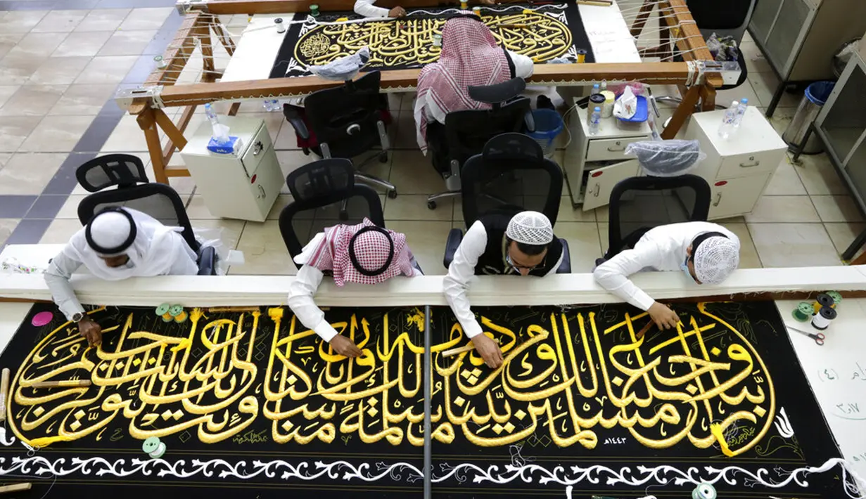 Pekerja menyulam kaligrafi Islam pada Kiswah Kabah menggunakan benang perak murni dan benang perak berlapis emas di pabrik Kiswah di Mekah, Arab Saudi, Rabu (14/7/2021). Kiswah yang menutupi Kabah diganti setiap tahun untuk umrah atau haji. (AP Photo/Amr Nabil)