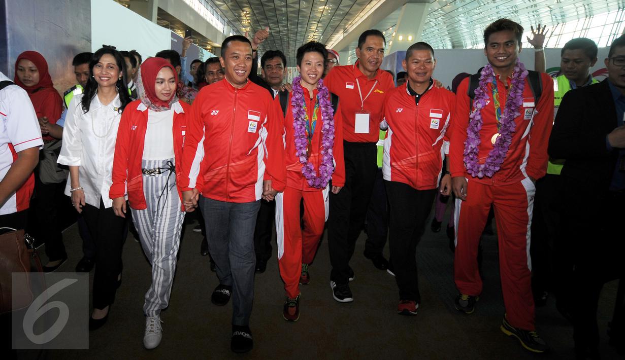 Ketua Umum PBSI, Gita Wirjawan (keempat kanan) berjalan bersama Tontowi Ahmad dan Lilyana Natsir di Bandara Soetta, Banten, Selasa (23/8/2016). Tontowi Ahmad/Lilyana Natsir berhasil meraih emas olimpiade Rio 2016. (Liputan6.com/HelmiFithriansyah)