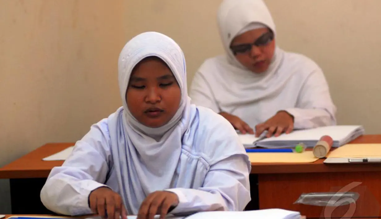  Dua Siswi penyandang disabilitas mengikuti Ujian Nasional SMP di SMPN 226 Pondok Labu, Jakarta Selatan, Senin (5/5/2014) (Liputan6.com/Miftahul Hayat). 