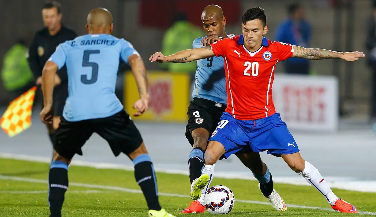 Gelandang Chile, Charles Aranguiz mengontrol bola dari hadangan dua pemain Uruguay di perempat final Copa Amerika 2015 di National Stadium, Santiago, Chile, (25/6/2015). Chile melaju ke semifinal usai mengalahkan Uruguay 1-0. (REUTERS/Ivan Alvarado)