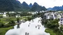 Foto dari udara memperlihatkan sejumlah wisatawan yang sedang menaiki rakit untuk menikmati pemandangan di Sungai Yulong di Wilayah Yangshuo, Kota Guilin, Daerah Otonom Etnis Zhuang Guangxi, China selatan (3/8/2020). (Xinhua/Li Bin)