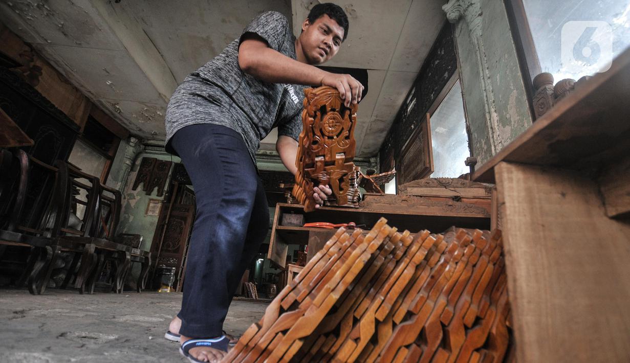 Pekerja menyelesaikan pembuatan rehal atau meja untuk Al-qur’an di Toko Mabruri 12, Klender, Jakarta, Rabu (13/4/2022). Harga rehal di toko ini dibanderol mulai dari Rp50.000 hingga Rp300 ribu per buah, tergantung ukuran dan jenis kayu. (merdeka.com/Iqbal S Nugroho)
