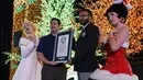 Pihak Guinness World Record menyerahkan piagam kepada Universal Studio Singapore yang telah berhasil memecahkan rekor dunia hiasan lampu Natal sebanyak 824.961 buah, Kamis (17/11).  (AFP PHOTO/ Roslan Rahman)