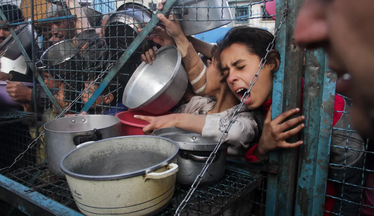 Pengungsi Palestina mengantre untuk mendapatkan makanan gratis di kamp pengungsi Jabaliya di Jalur Gaza pada Senin, 18 Maret 2024. (AP Photo/Mahmoud Essa)