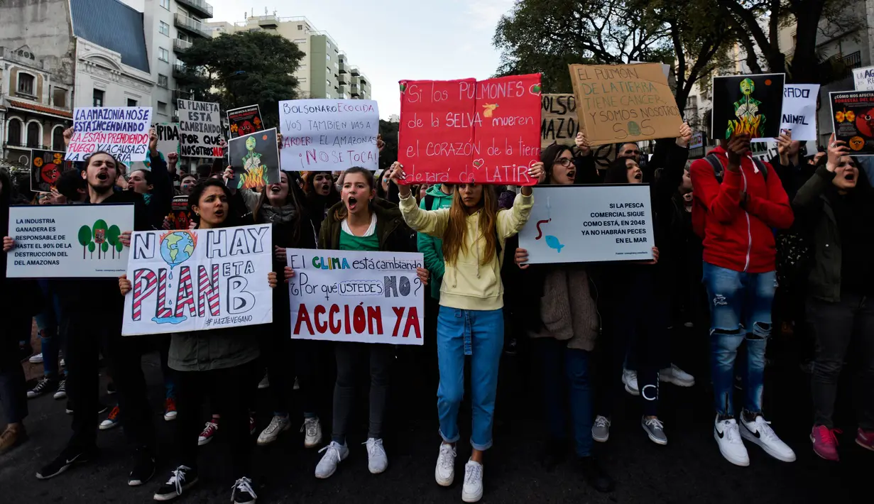 Demonstran memblokir jalan di luar Kedutaan Brasil selama protes yang diselenggarakan oleh gerakan Jumat Untuk Masa Depan menyerukan Presiden Brasil Jair Bolsonaro untuk melindungi hutan Amazon di Montevideo, Uruguay, Jumat (23/8/2019). (AP Photo/Matilde Campodonico)