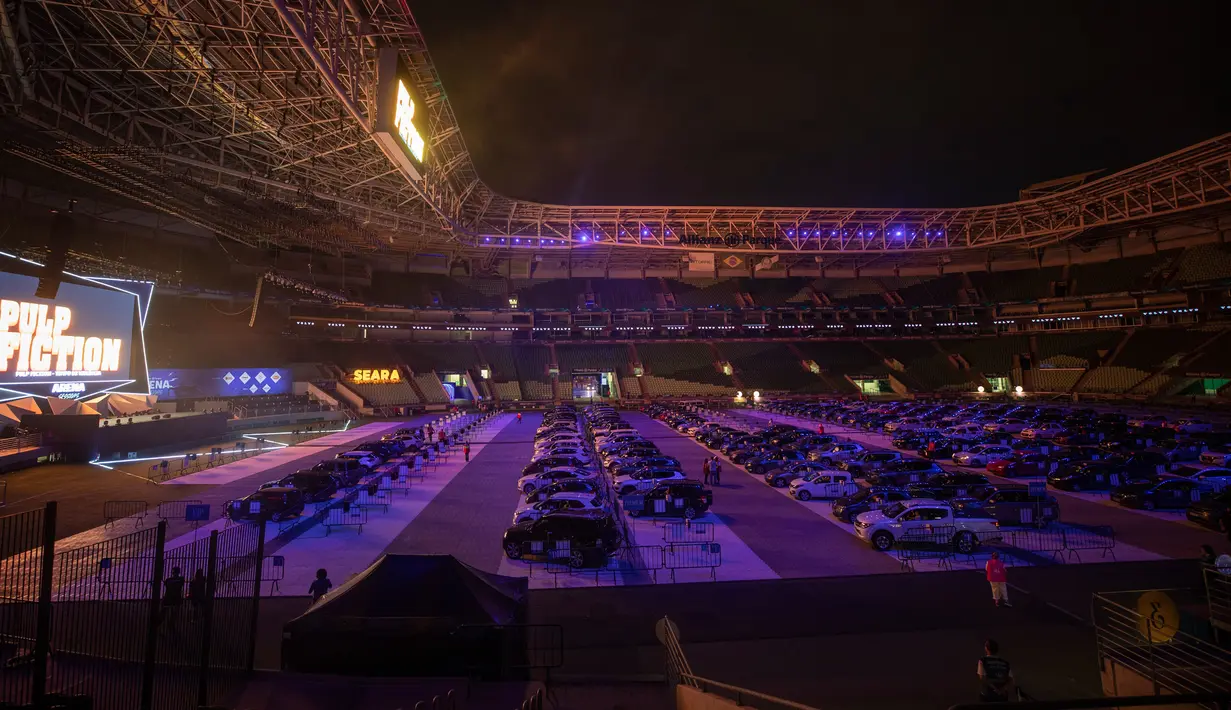 Orang-orang menonton film dari dalam mobil mereka di drive in yang dipasang di stadion sepak bola Palmeiras di Sao Paulo, Brasil, Kamis (25/6/2020). Stadion yang dapat menampung hingga 300 mobil tersebut berubah fungsi menjadi lokasi bioskop drive ini di masa pademi Covid-19. (AP Photo/Andre Penner)
