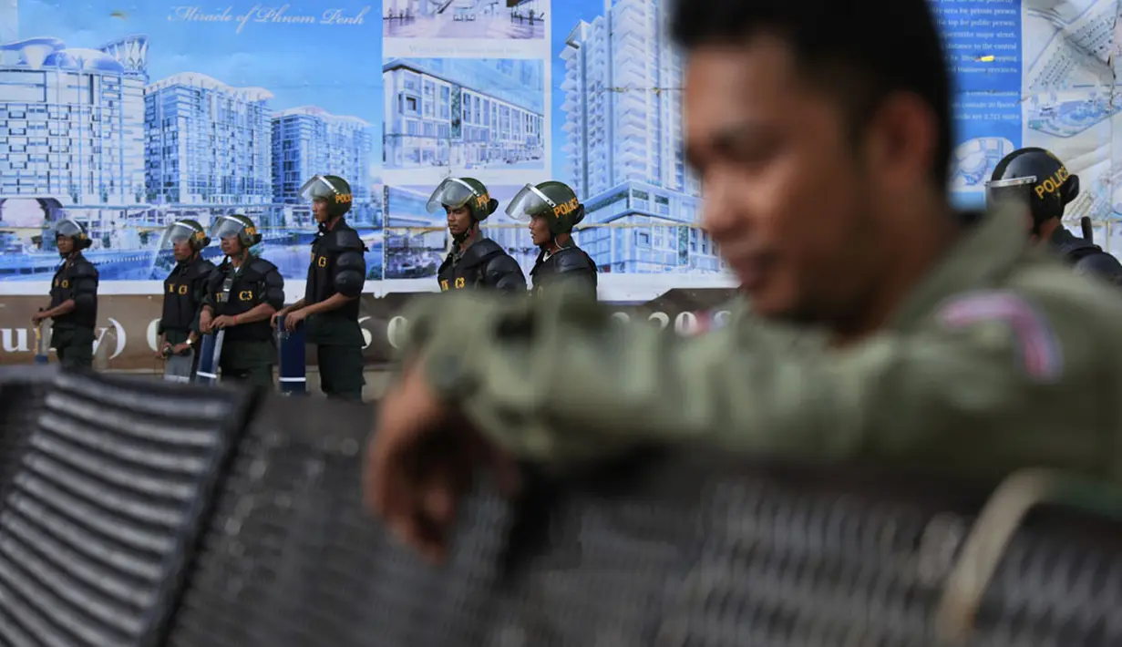 Polisi antihuru hara bersiaga dan memblokir jalan di dekat Phnom Penh Municipal Court di pusat kota Phnom Penh, Kamboja (30/5/2014). (REUTERS/Samrang Pring)