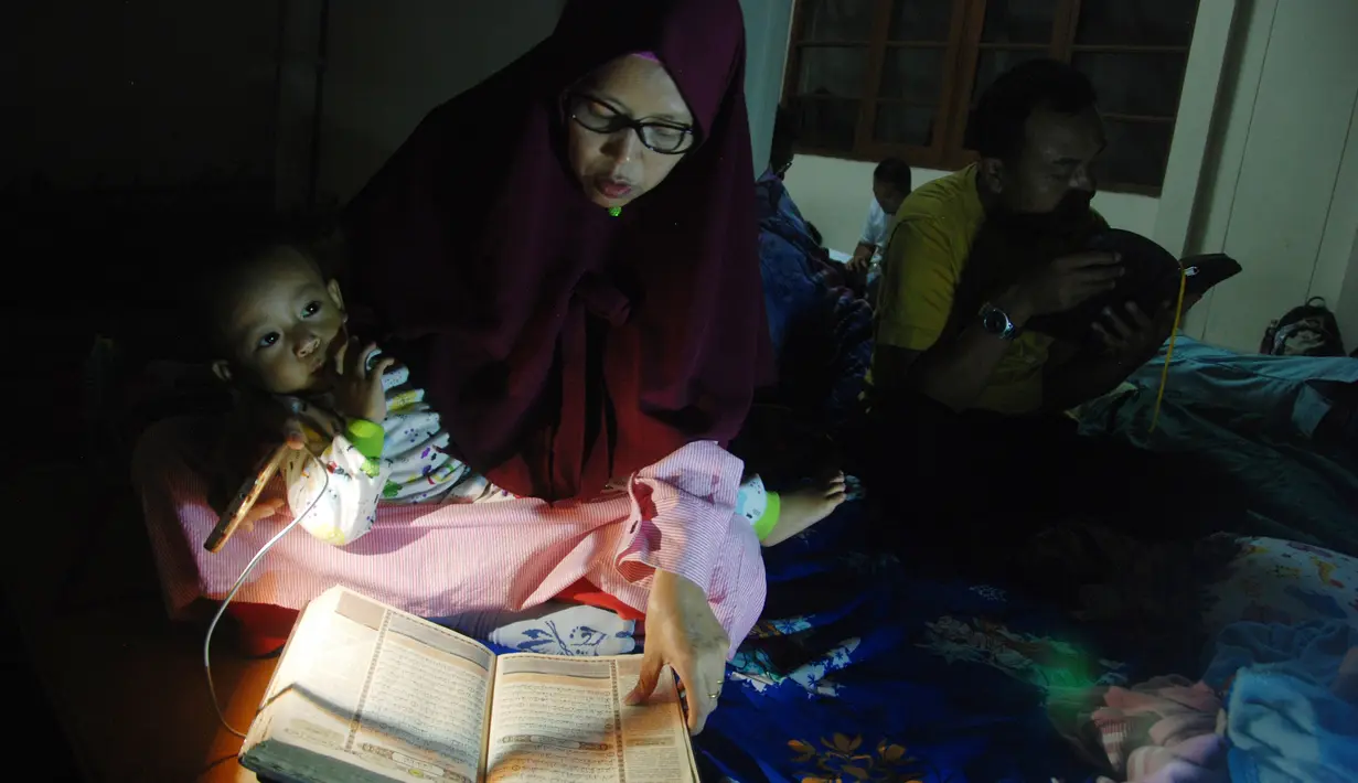 Warga membaca Alquran saat melakukan iktikaf di sebuah masjid di Bandung (6/6). Mereka melakukan iktikaf di masjid dengan mendirikan tenda. (AFP/Timur Matahari)