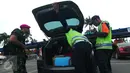 Petugas memeriksa bagasi mobil yang masuk di kawasan bandara Soetta Tangerang, Kamis, (14/01/16). Sejumlah anggota Kepolisian dan TNI AD dikerahkan untuk melakukan penjagaan di Bandara Soetta. (Liputan6.com/Faisal R Syam)