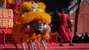 Robot-robot tersebut dirancang melakukan gerakan tarian yang lincah, dinamis, dan mengikuti irama musik tradisional. Tampak dalam foto, sebuah robot humanoid dengan pakaian merah meriah memberi isyarat di atas panggung sementara robot berkaki empat yang dilengkapi kepala singa tampil di latar depan selama hari kedua perayaan Tahun Baru Imlek 2577 Kongzili di sebuah pekan raya kuil di Beijing pada Rabu 18 Februari 2026. (AP Photo/Vincent Thian)