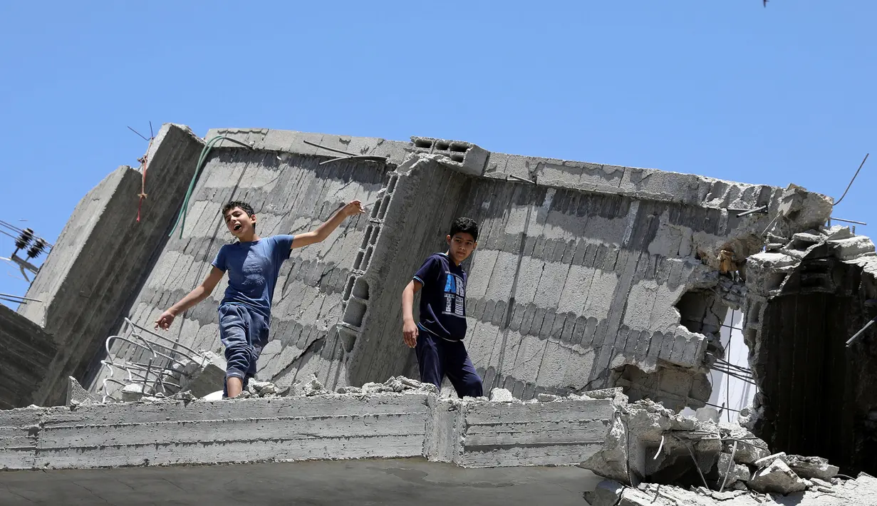 Seorang bocah Palestina menari di atas puing-puing sebuah bangunan yang baru-baru ini hancur oleh serangan udara Israel selama acara musik di kota Gaza, Selasa (14/5/2019). Acara itu menyerukan pemboikotan terhadap Kontes Lagu Eurovision 2019 yang diselenggarakan di Israel. (REUTERS/Mohammed Salem)