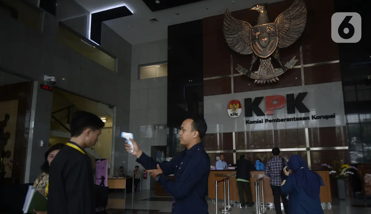 Petugas mengecek suhu tamu dan pegawai yang akan masuk ke Loby di Gedung KPK, Jakarta, Kamis, (12/3/2020). KPK menerapkan pengecekan suhu tubuh tersebut untuk mengantisipasi penyebaran virus corona atau covid-19. (merdeka.com/Dwi Narwoko)